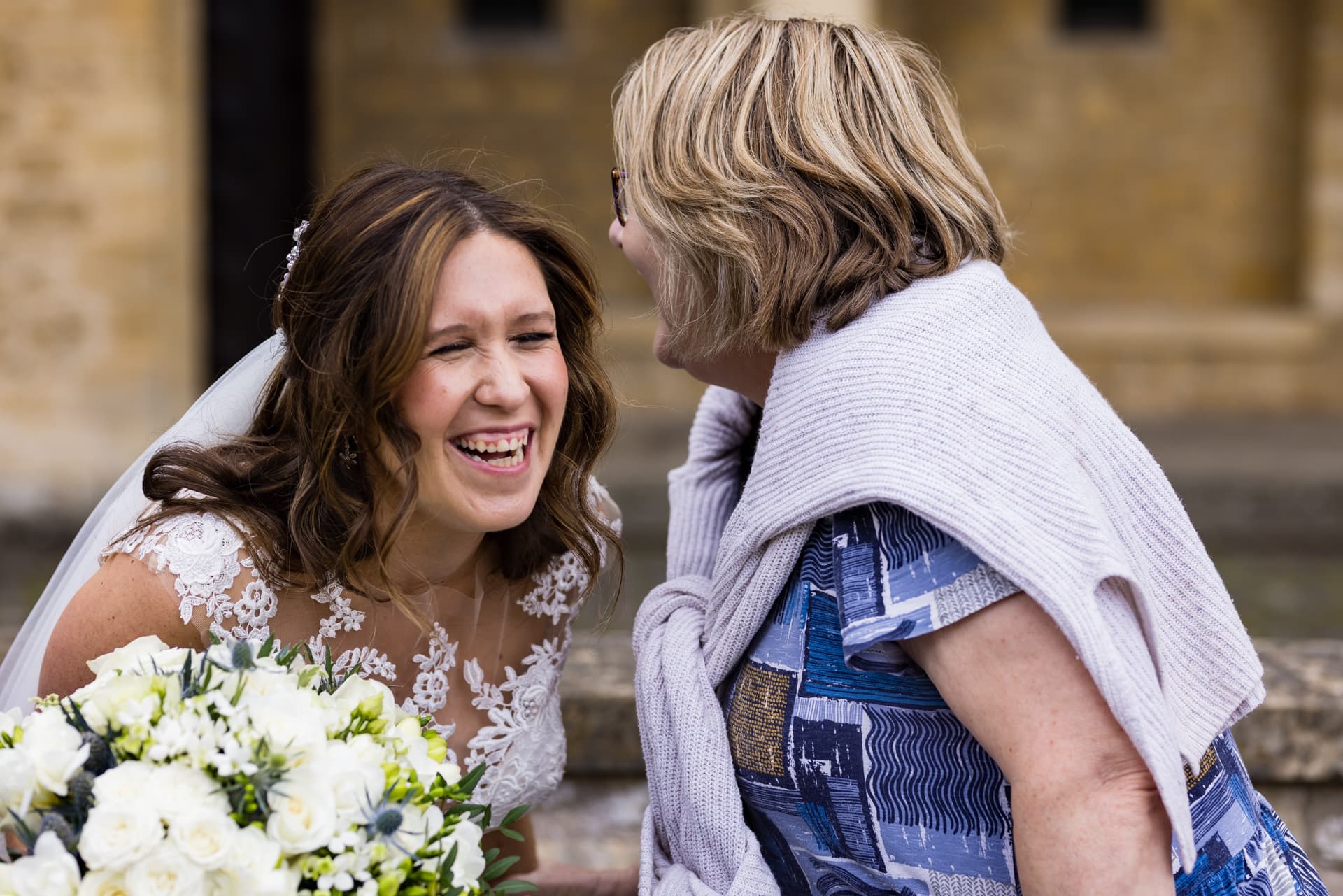 Bride with old friend laughing
