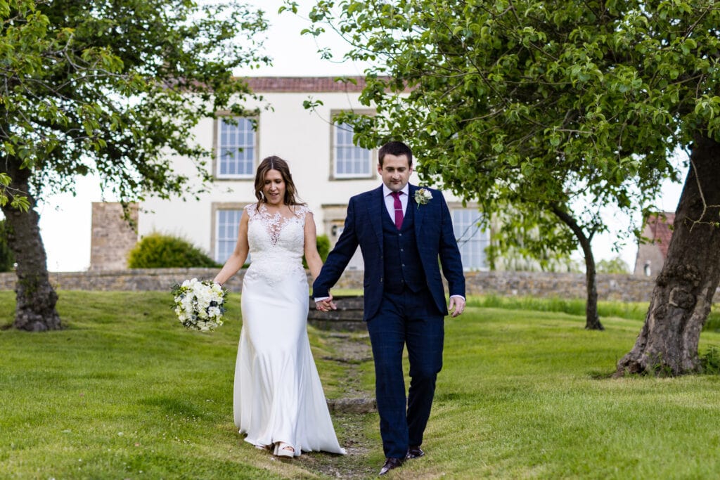 Wedding couple walking away from cottage