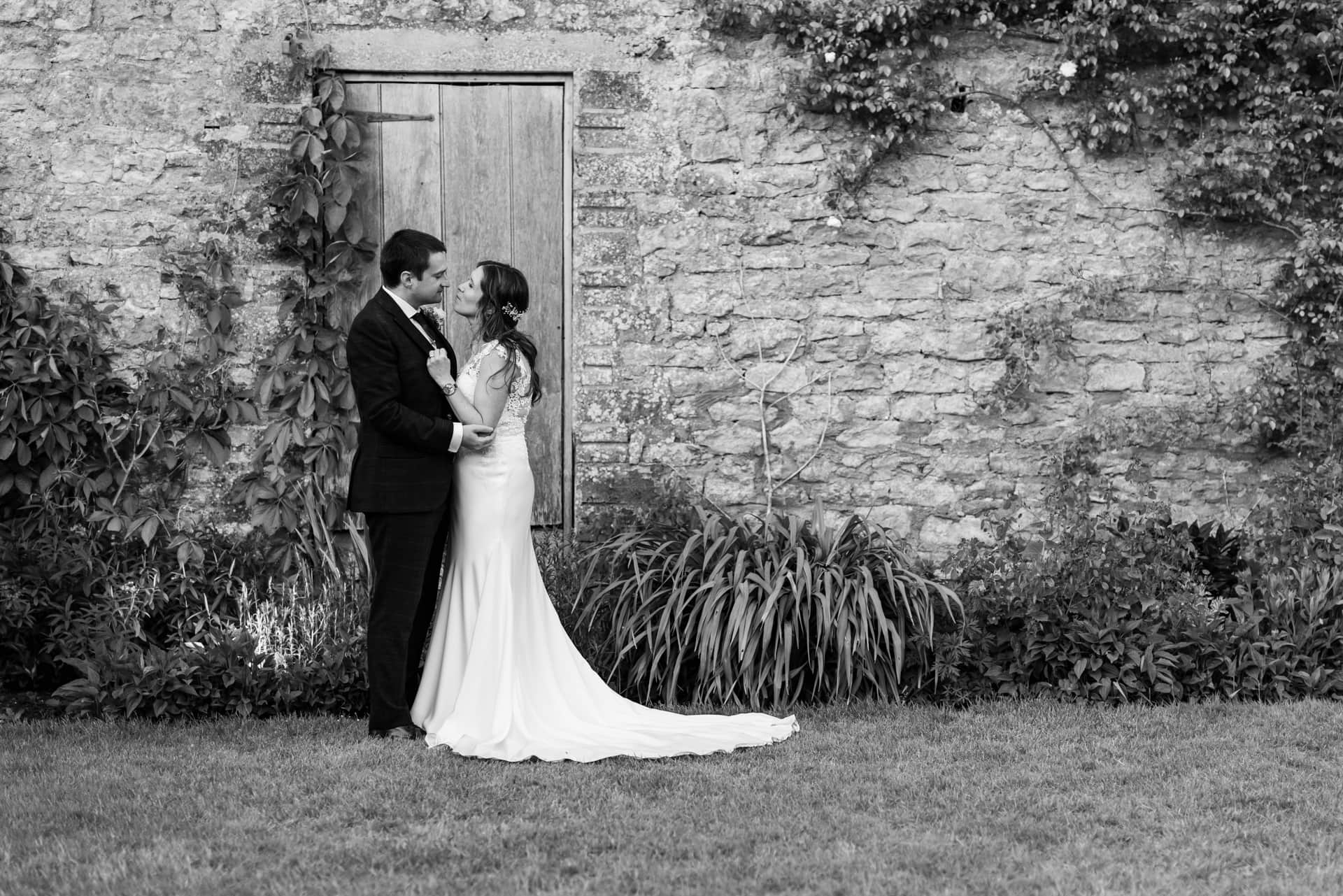 Black and white wedding couple outside barn in the grounds of Priston Mill Wedding Venue