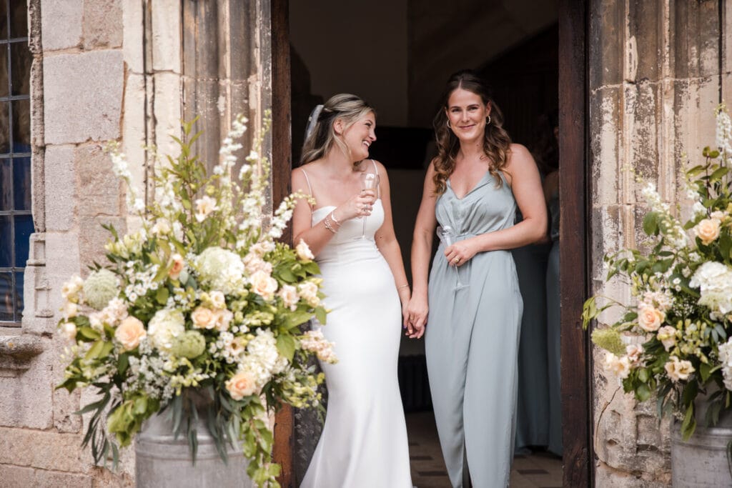 Bride and Bridesmaid laughing on door step of Berkeley Castle Wedding Venue