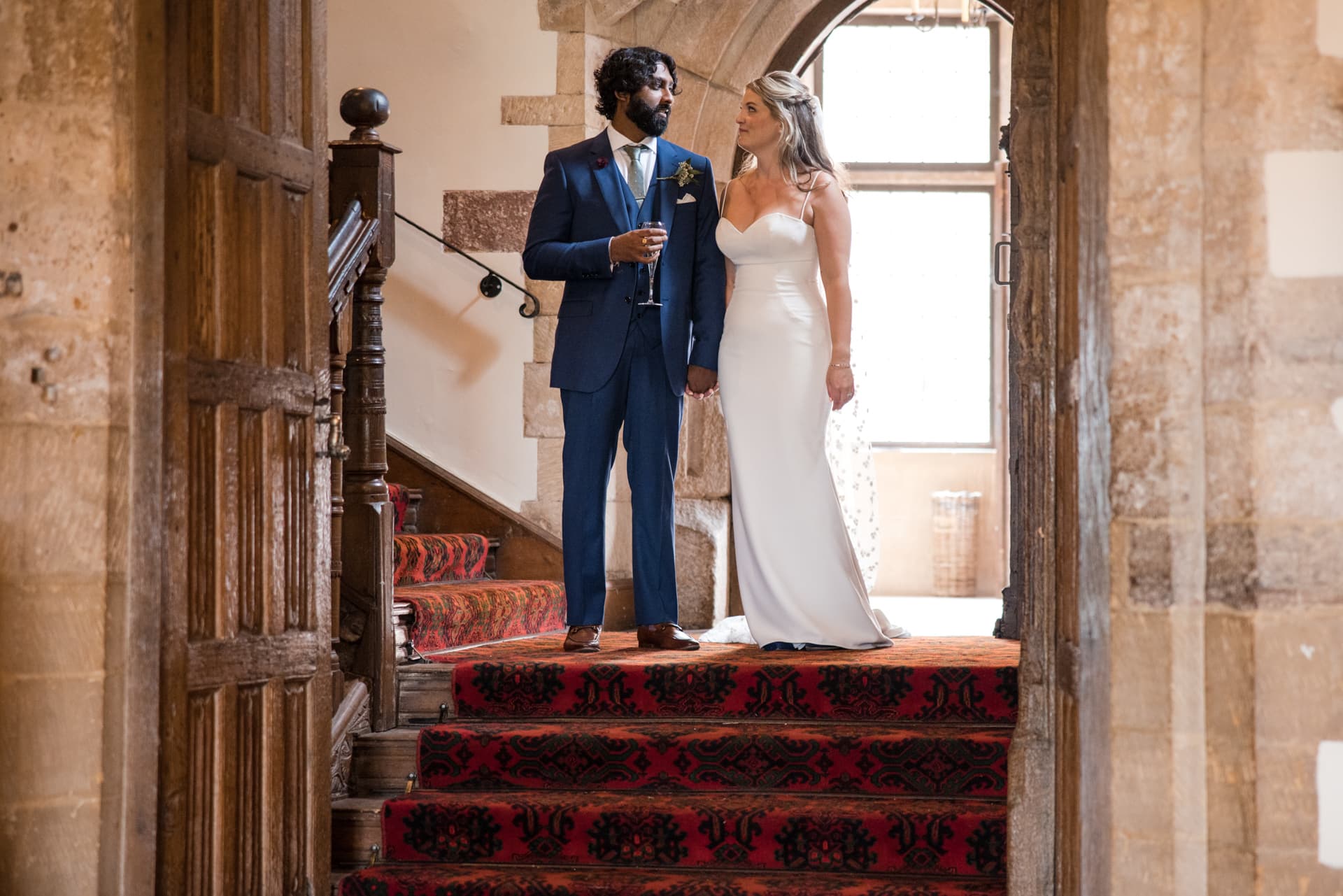 Bride and Groom looking at each other of the stairs.