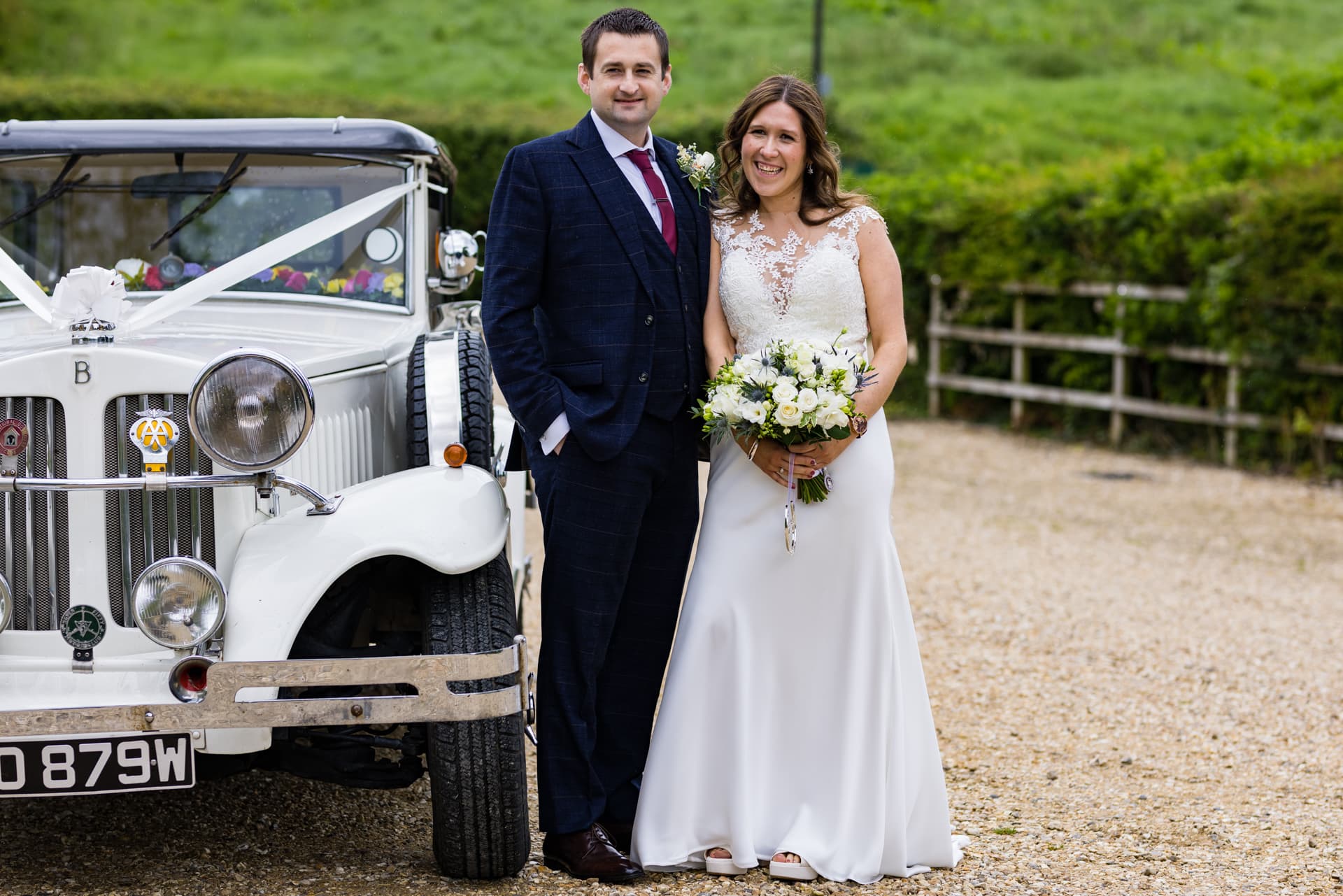 bride and groom next to vintage car outside Priston Mill Wedding Venue