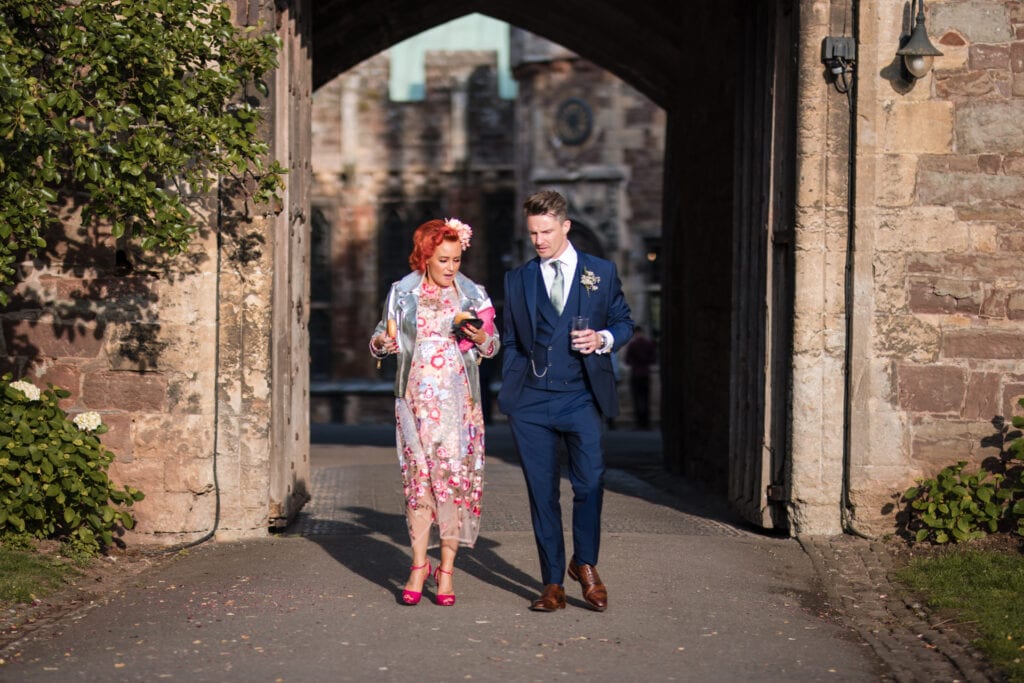 Wedding guests walking through castle archway