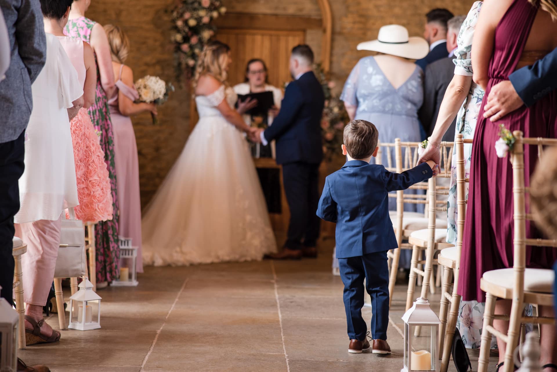 Young boy in suit looks at Bride and Groom during ceremony