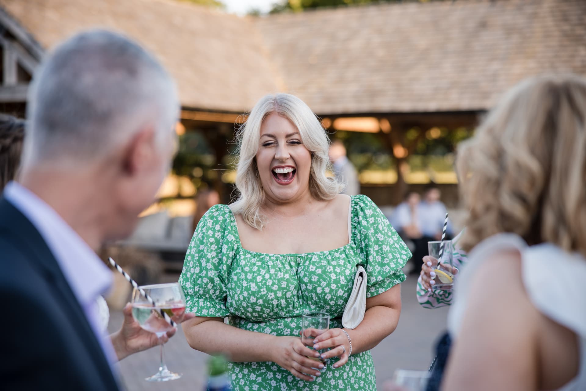 Lady in green dress laughing at wedding