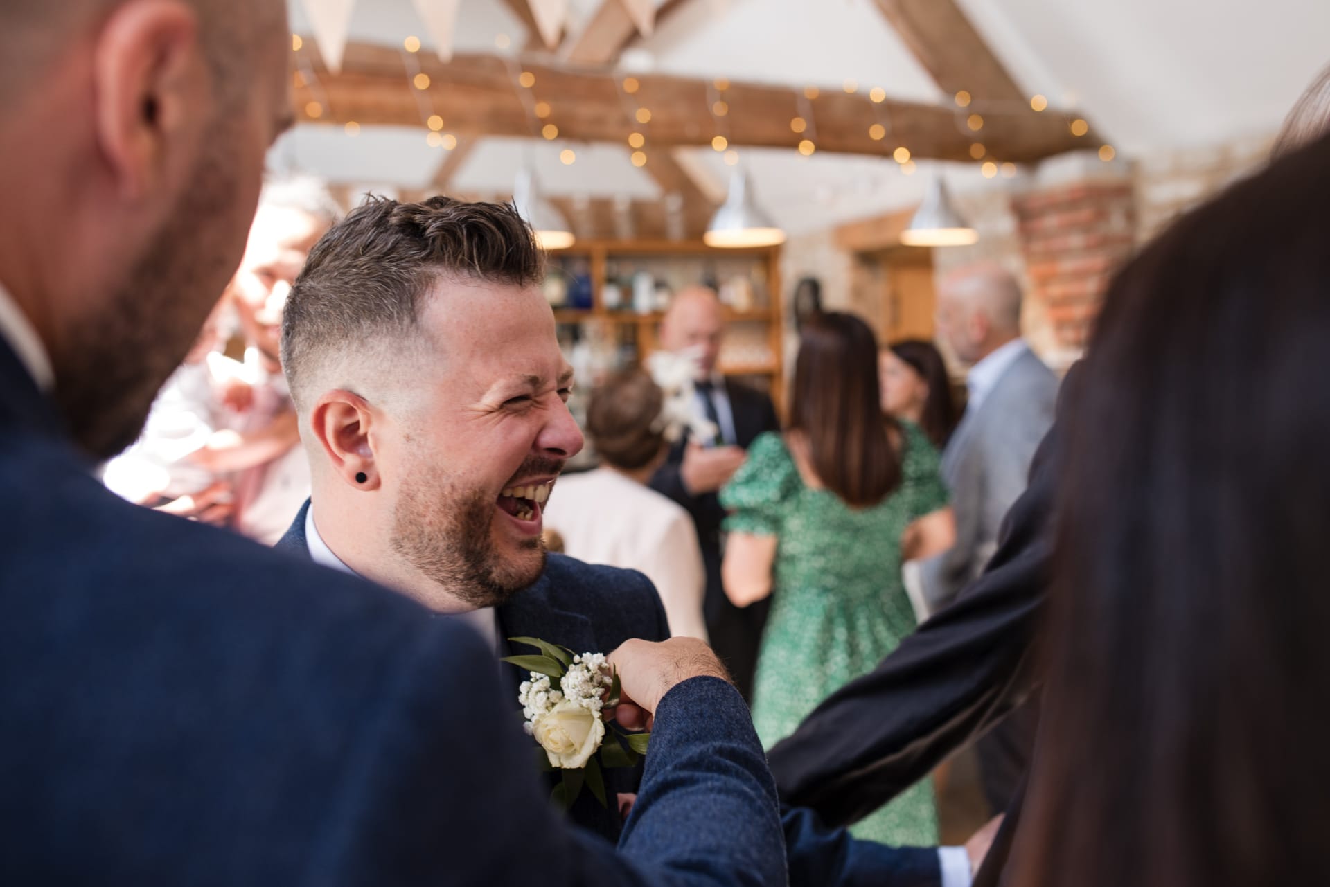 Fixing the pin on the groom whilst he is laughing