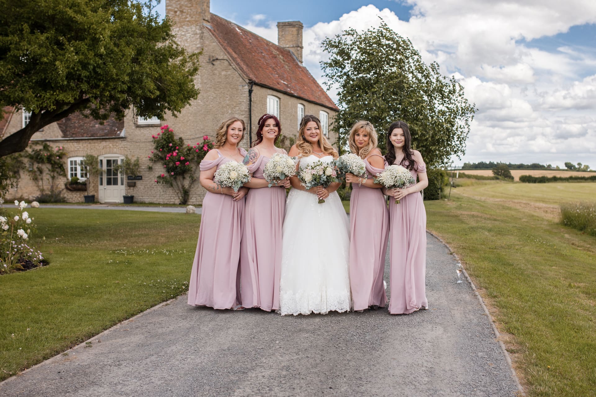 Bride and Bridesmaids with Farmhouse in the background