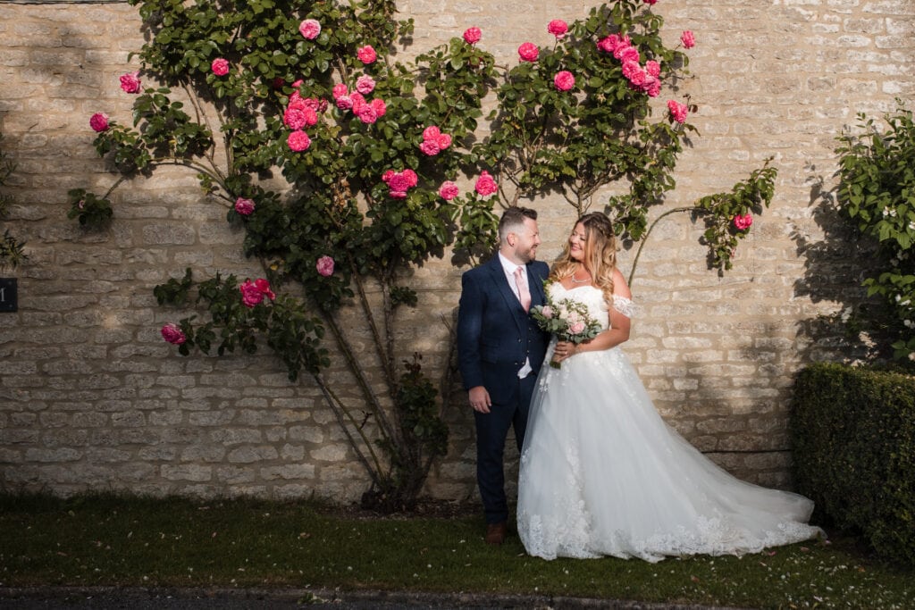 Bride and Groom in front of rose bush
