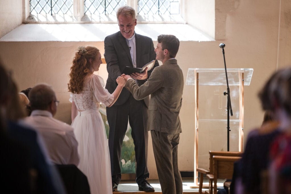 Bride and Groom with the Vicar during ceremony