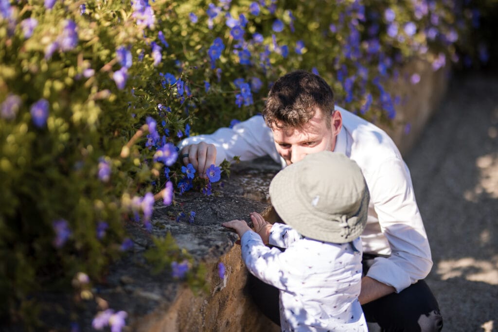 Toddler looking at the flowers in the gardens of Oxleaze Barn