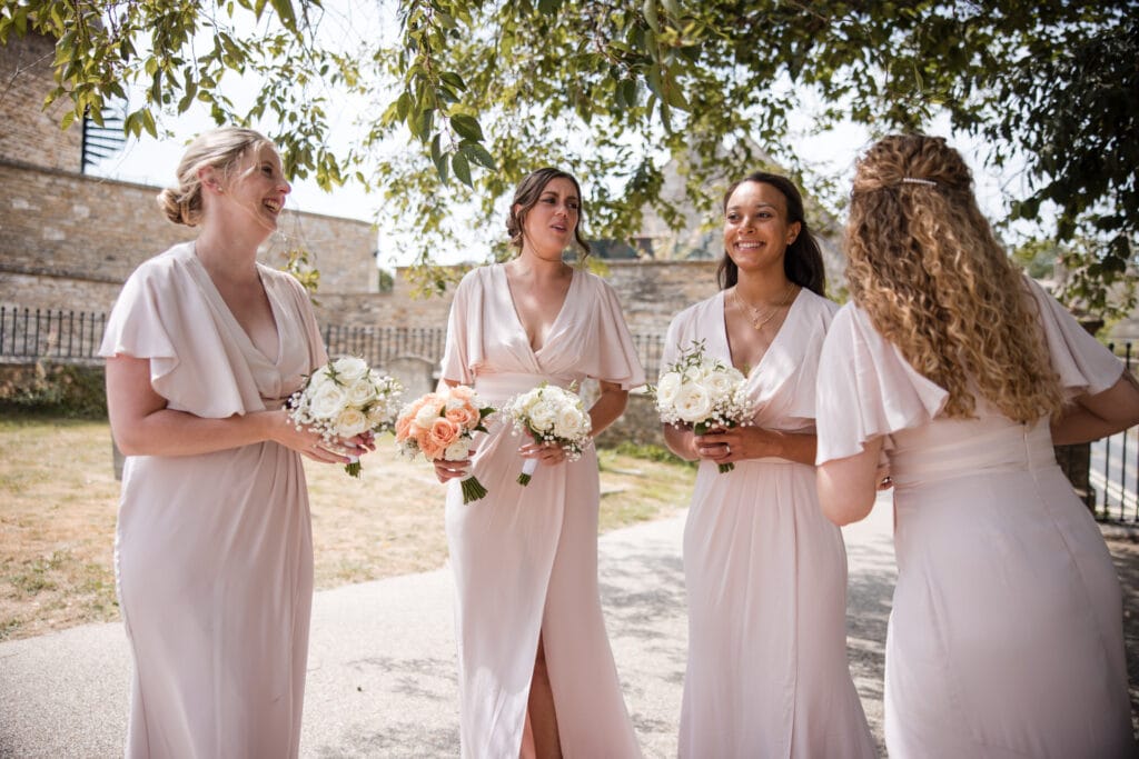 Bridesmaids waiting outside church for Bride. Burford Wedding, Oxleaze Barn