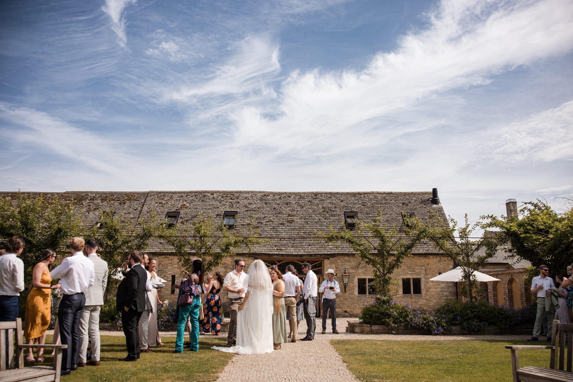 Oxleaze Barn with wedding party and blue sky