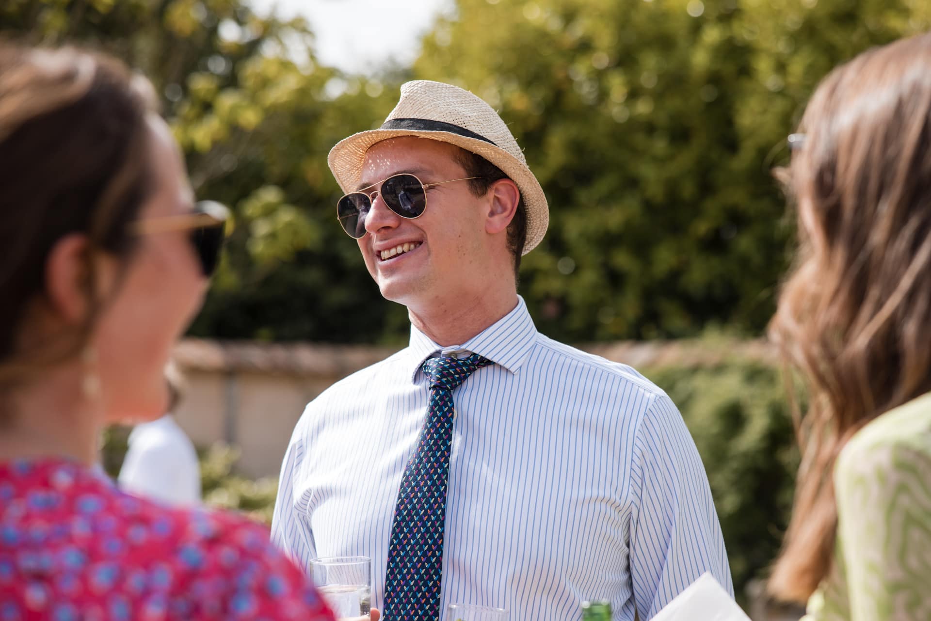 Wedding guest in shades and hat at Oxleaze Barn Wedding
