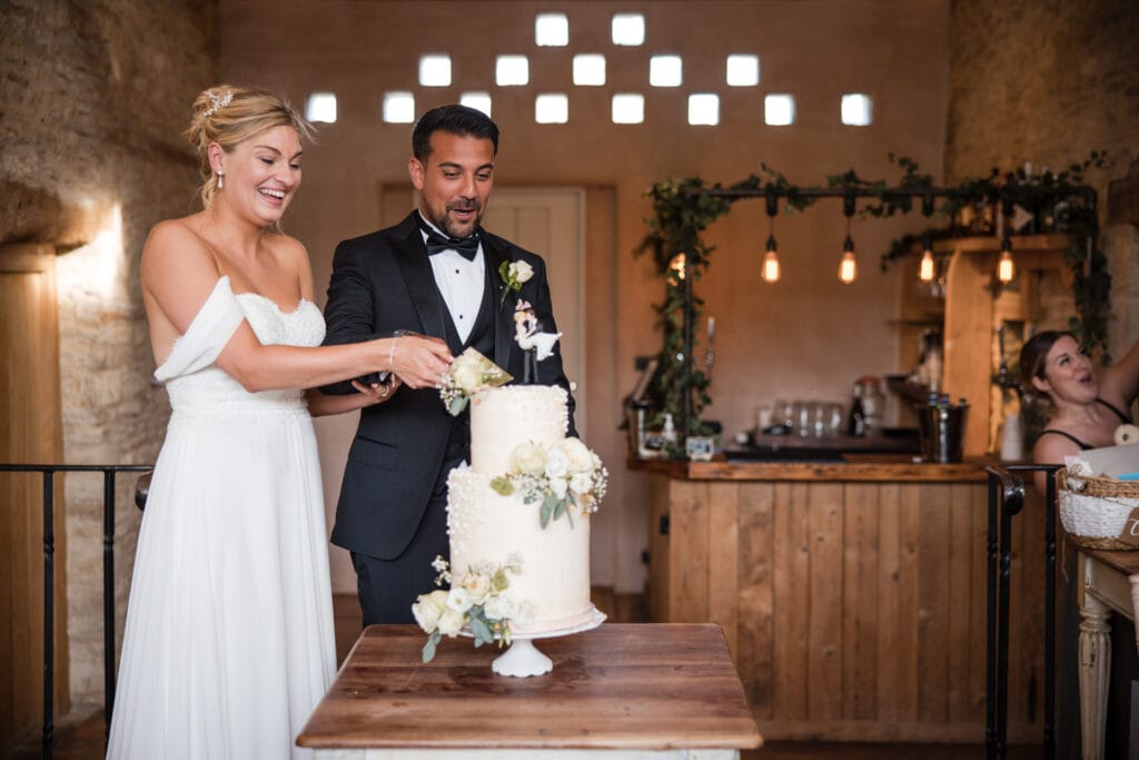 Cutting the wedding cake at Oxleaze Barn