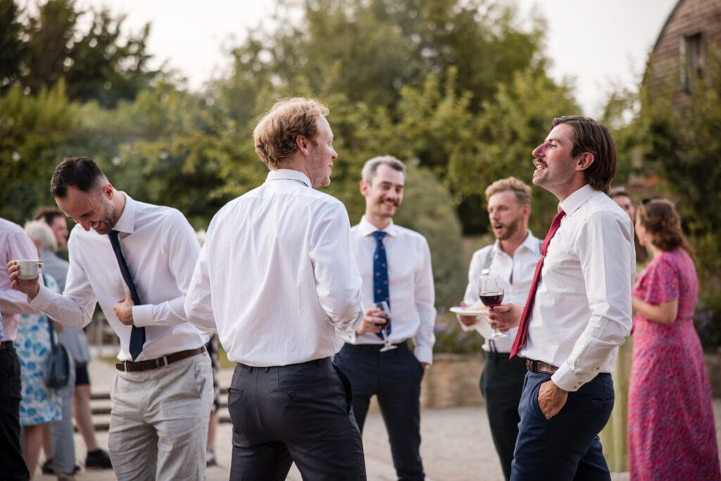 Wedding guests in the Courtyard at Oxleaze Barn