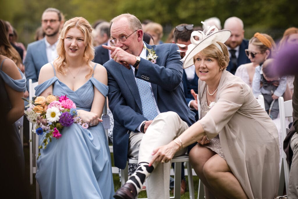 Brides mother pointing at fathers cow print socks