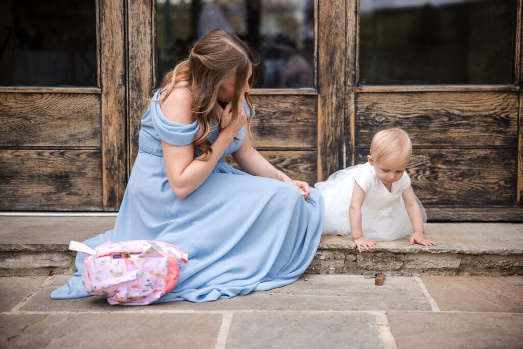 Bridesmaid and baby daughter playing at Kingscote Barn