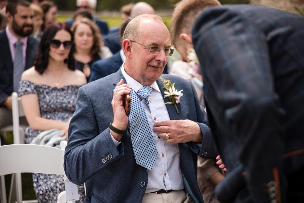 Groom admiring the Father of the Brides Shirt at Kingscote Barn