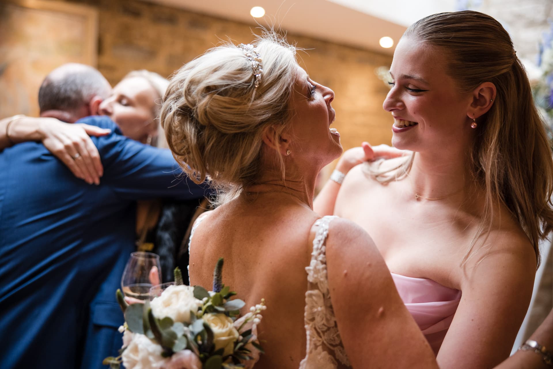 Bride and daughter hug after wedding ceremony at Le Manoir