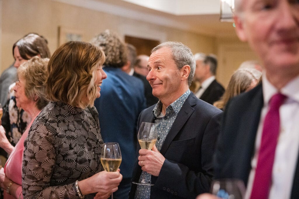 Two guests talking over a glass of wine at Le Manoir Wedding