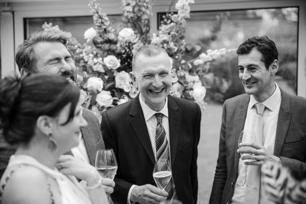 Guests joking over a glass of wine at Le Manoir