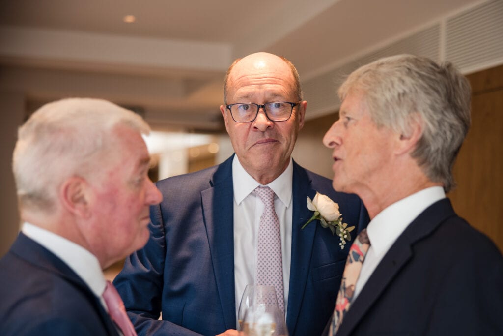 The Groom smirking at the camera whilst his friends chat away at Le Manoir