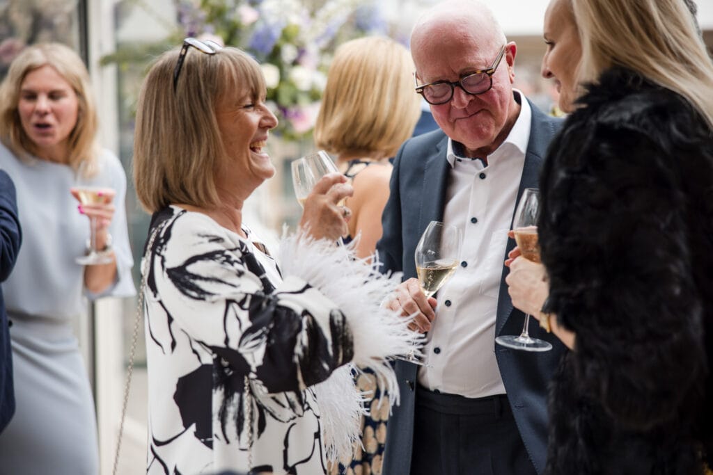 Guests laughing over a glass of Champagne at Le Manoir aux Quat’Saisons