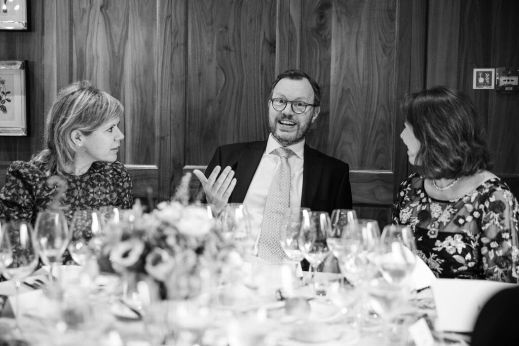 Guests gesturing at the wedding breakfast