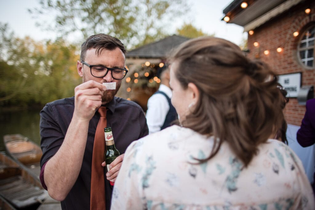 Wedding Guest reading the text on a tiny letter.