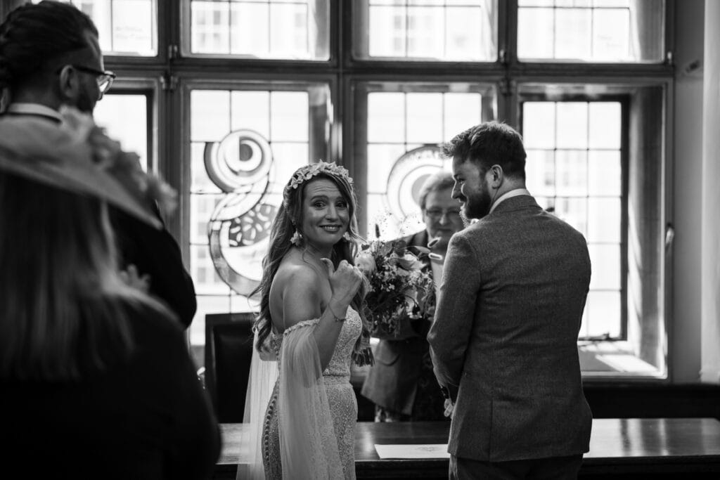 Bride thumbs up at just being married at Oxford County Hall