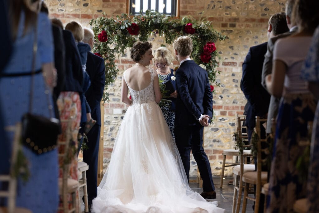 Bride looking back excited whilst being married at the Gathering Barn