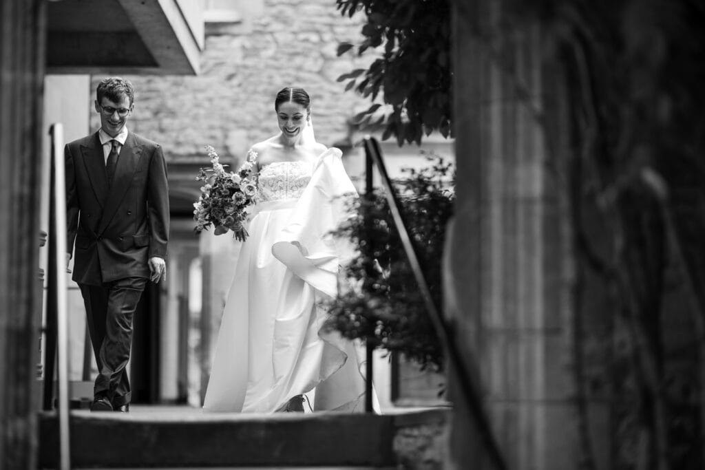 The Bride and Groom smiling in the grounds of Pembroke College