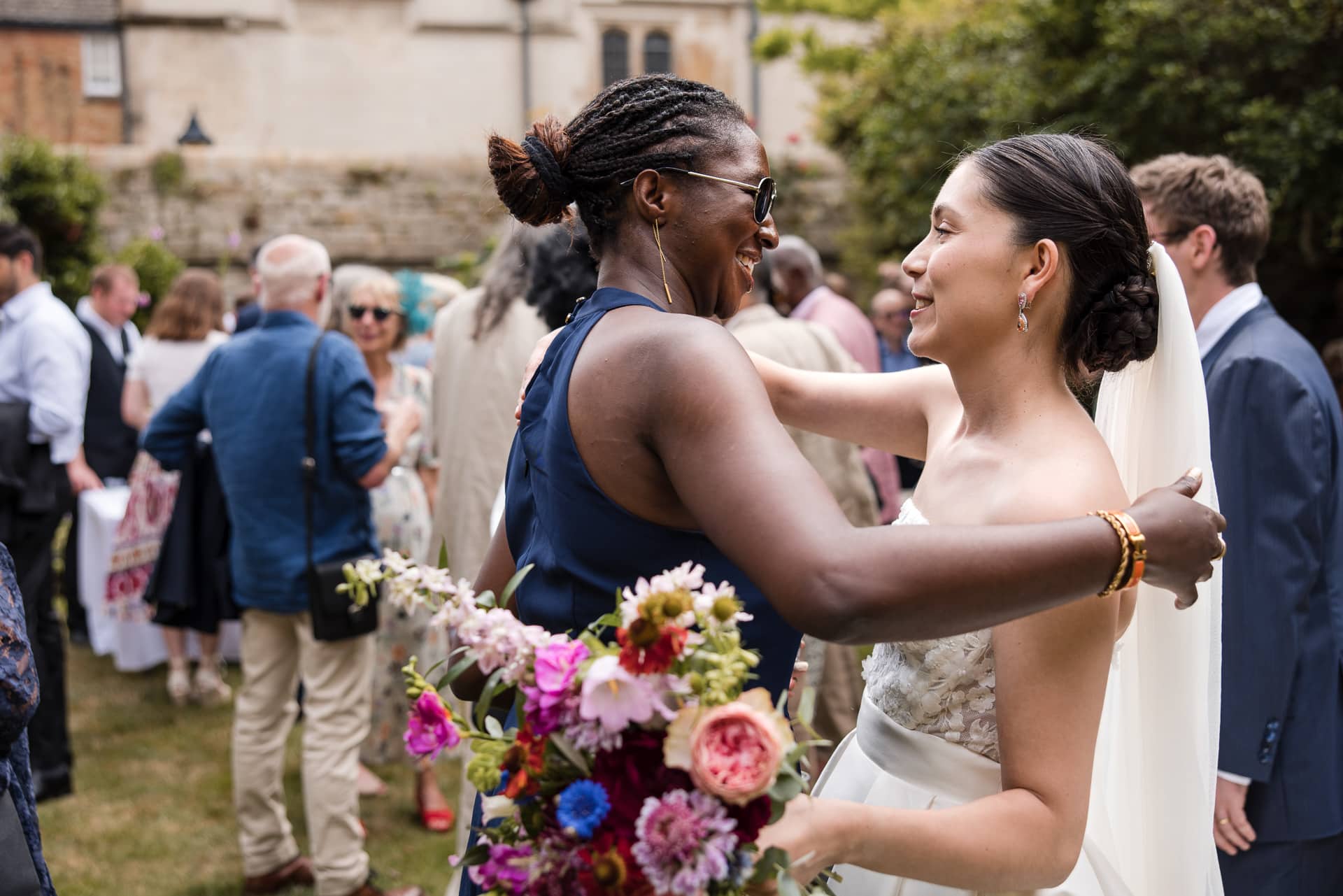 The Bride and Guest embracing each other in the Master’s Garden at Pembroke College