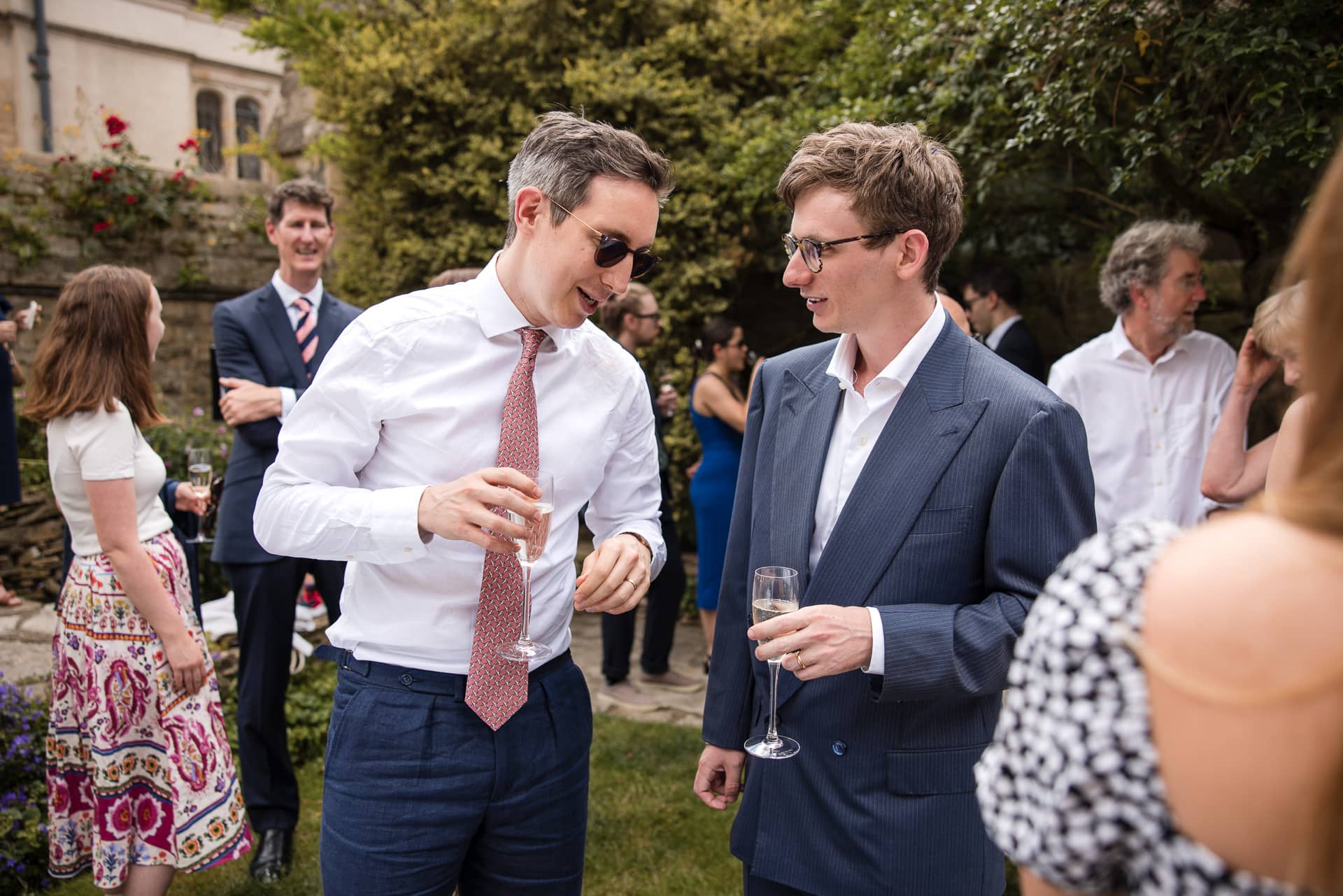 The Groom talking to a guest in the Masters Garden at Pembroke College