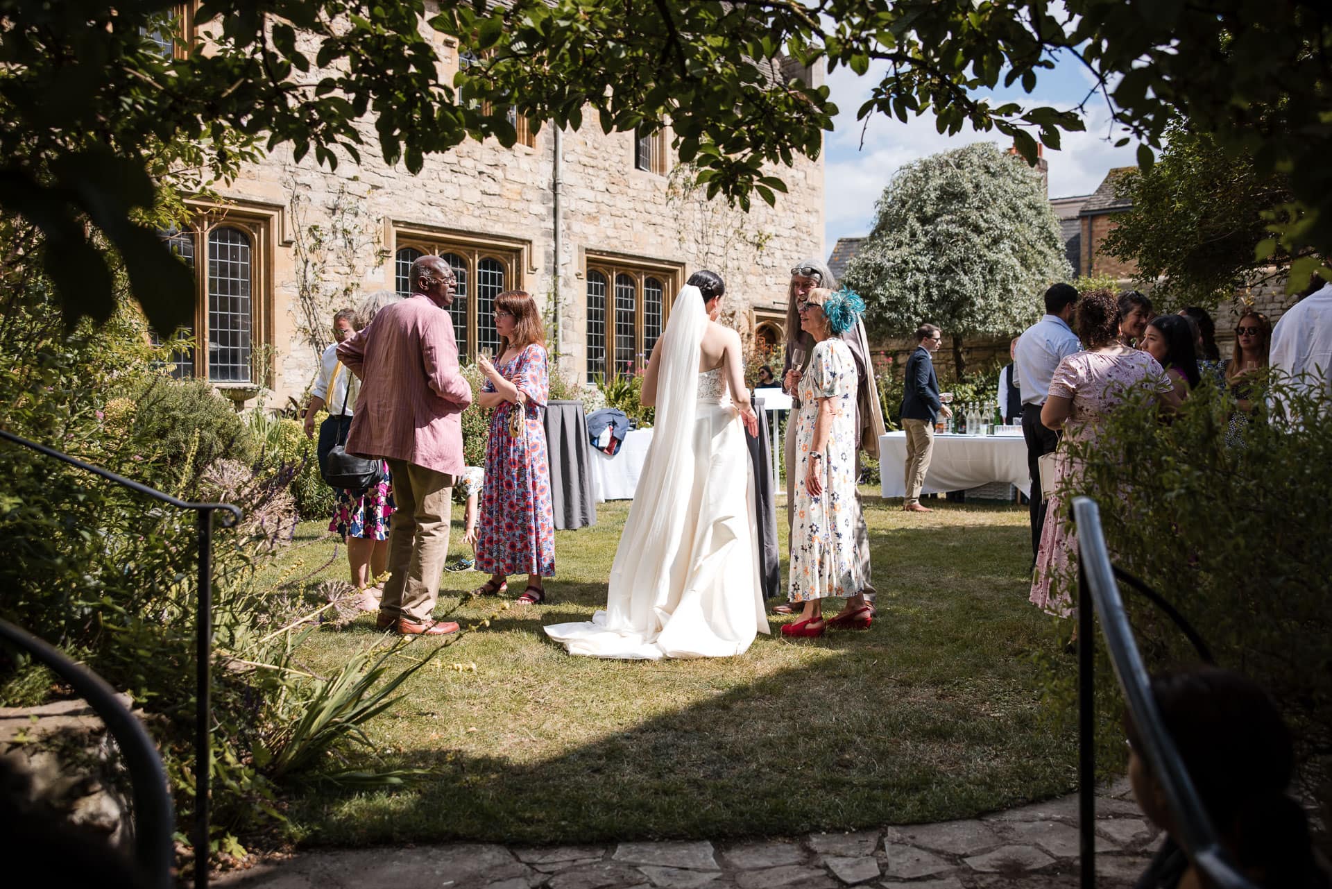 A Wide shot of the wedding guests in the Masters Garden at Pembroke College.