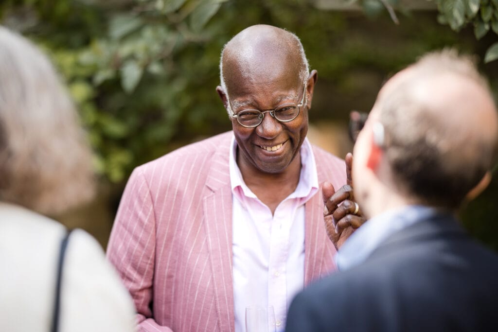 Guests laughing in the grounds of the Masters Garden at Pembroke College.