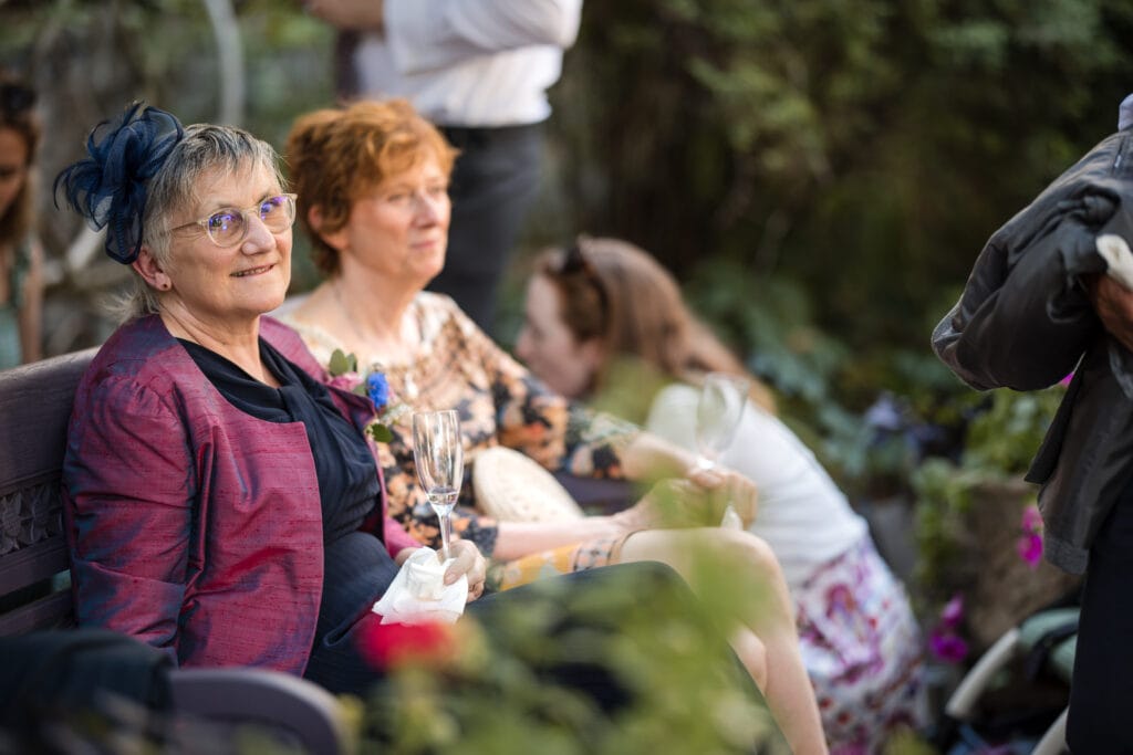 The mother of the groom looking on in the Masters Garden at Pembroke College.