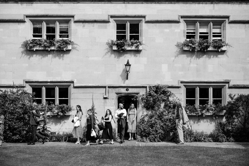 Wedding guests walking inside the grounds of Pembroke College