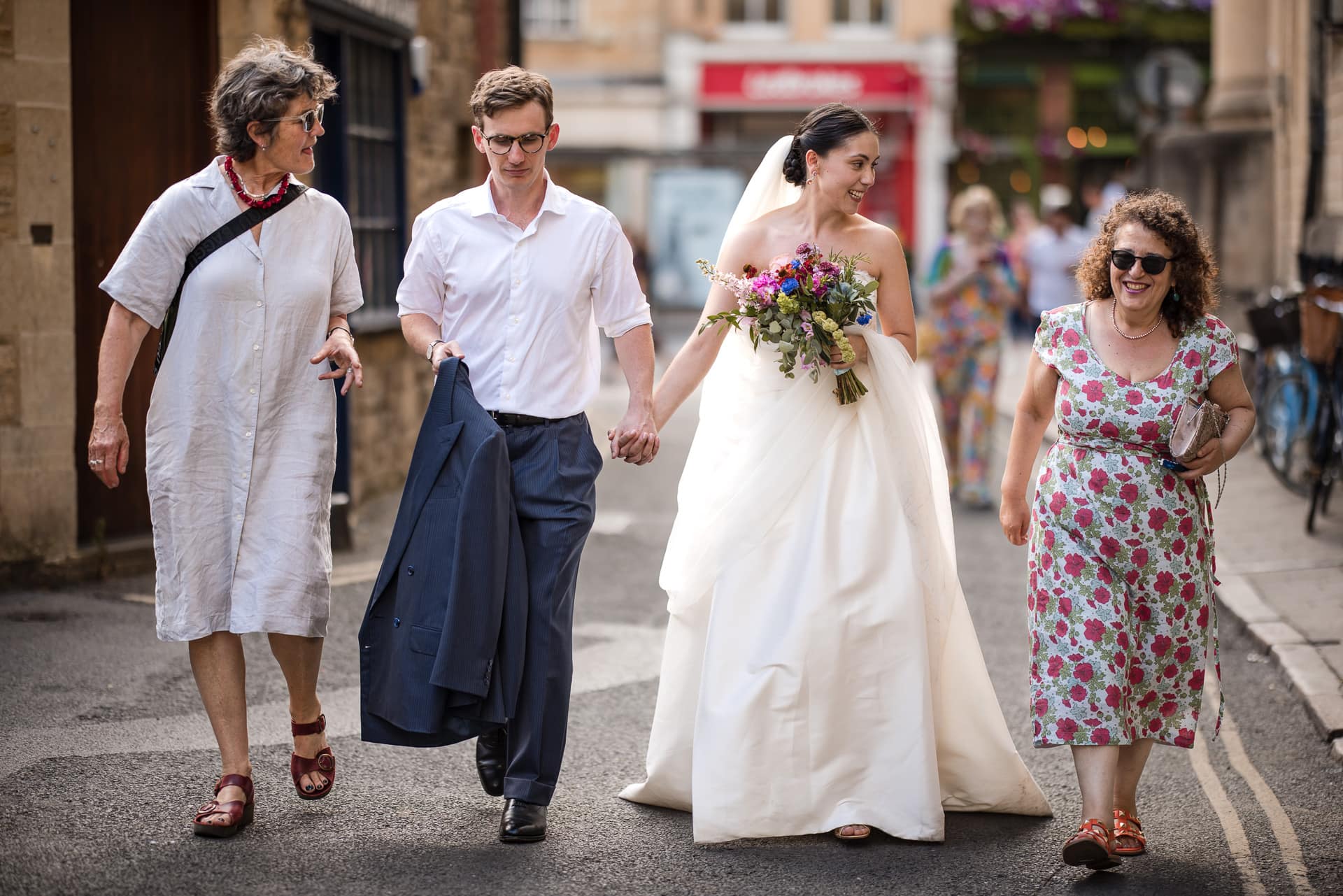 The Bride and Groom and two guests walking through Oxford City Centre.
