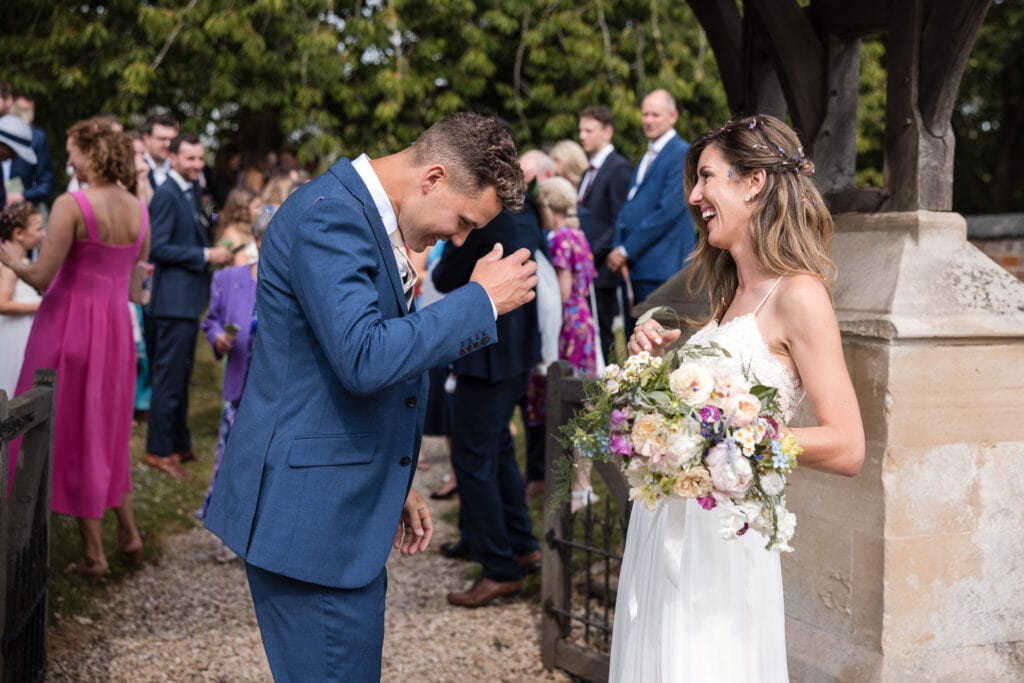 Bride and Groom laughing after the confetti line up at the Sandhurst Wedding