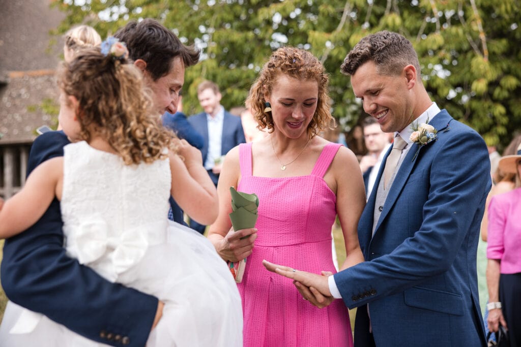 Grooms sister looking at his wedding ring.