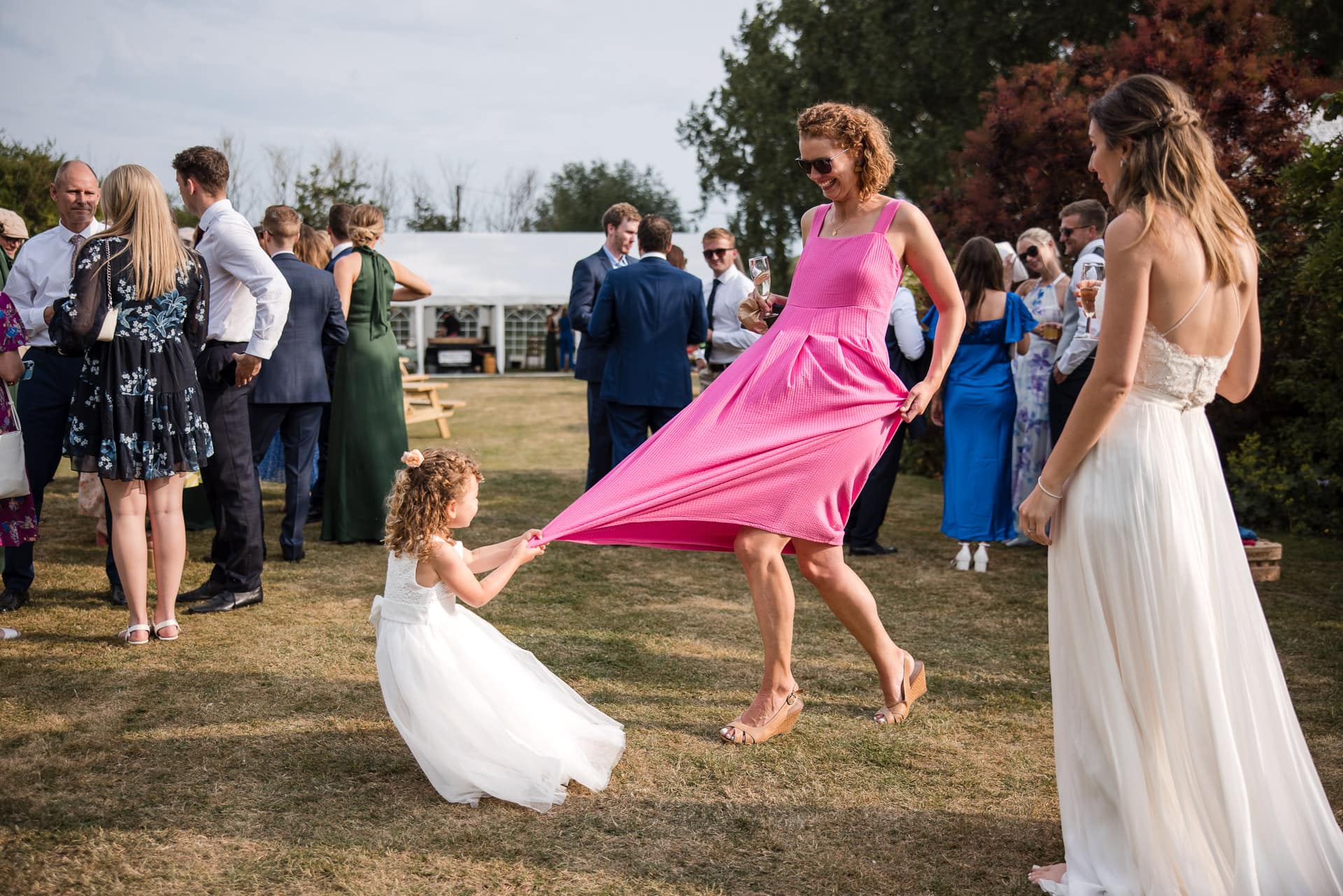 Young girl pulling at mums pink dress during the Sandhurst Farm Wedding Reception.