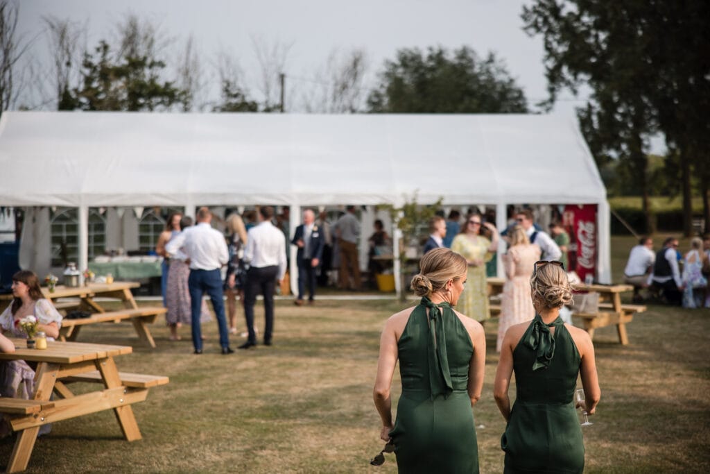 Bridesmaids walking towards the drinks marquee at the Cotswold wedding