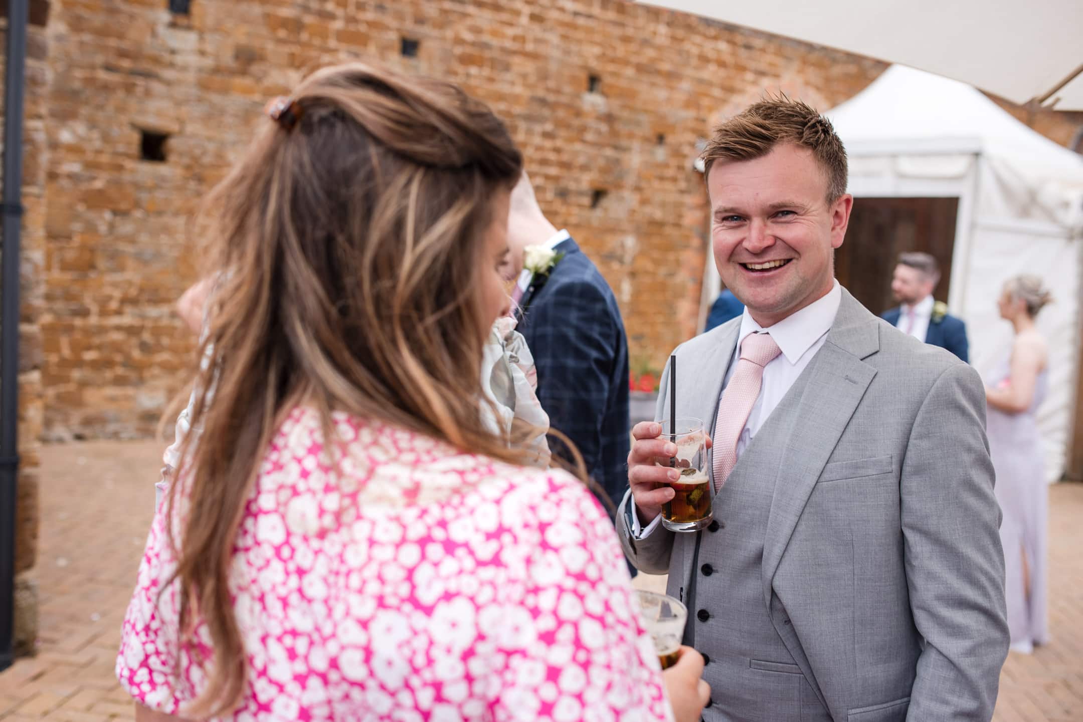 Couple drinking Pimms at Dovecote Barn Wedding
