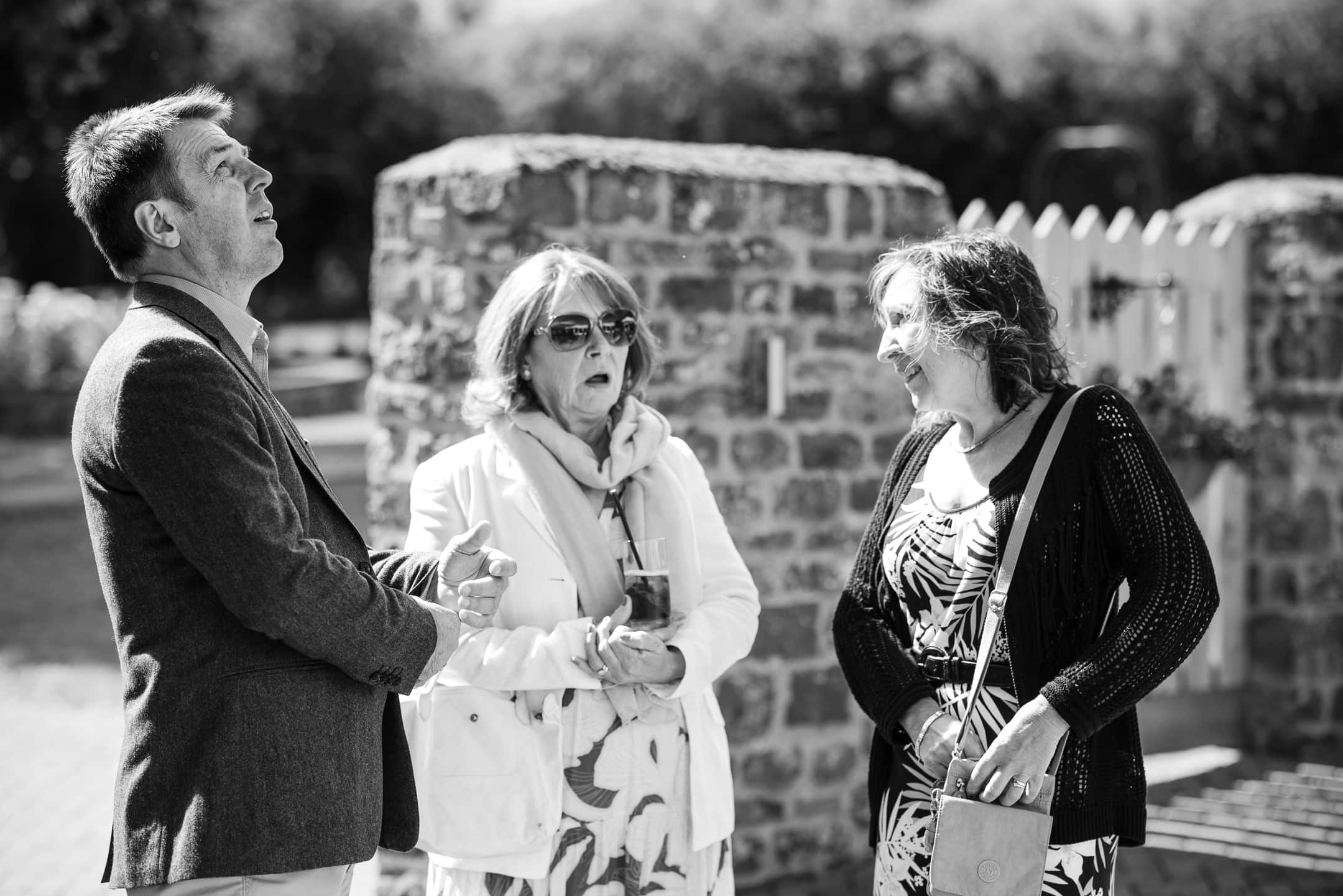 Guests talking whilst one looks up at the sky in the grounds of Dovecote Barn