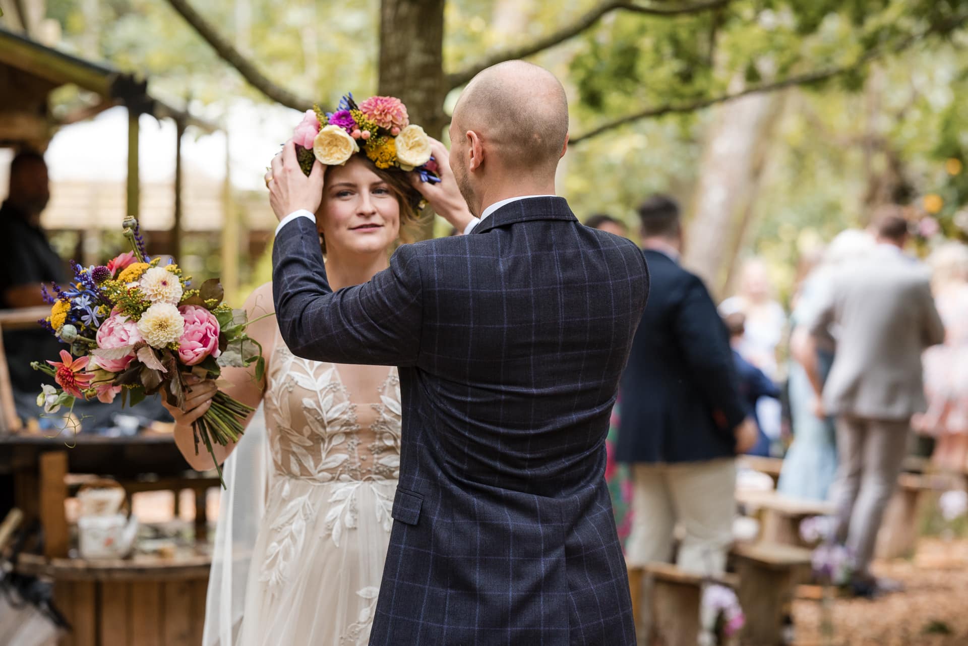 Groom aligning flowers on Brides head.