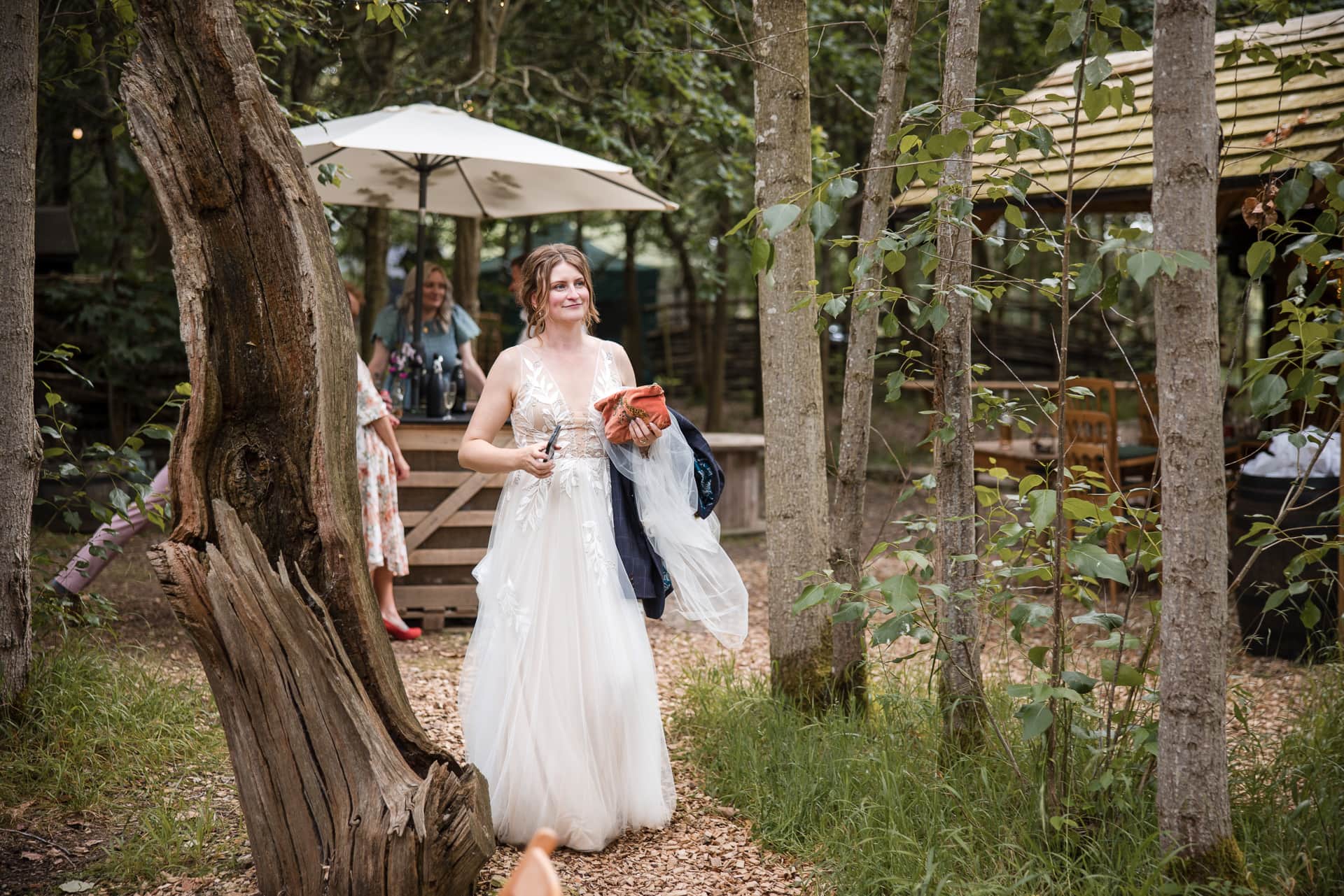 Bride walking within the trees at the Endeavour Woodland wedding venue