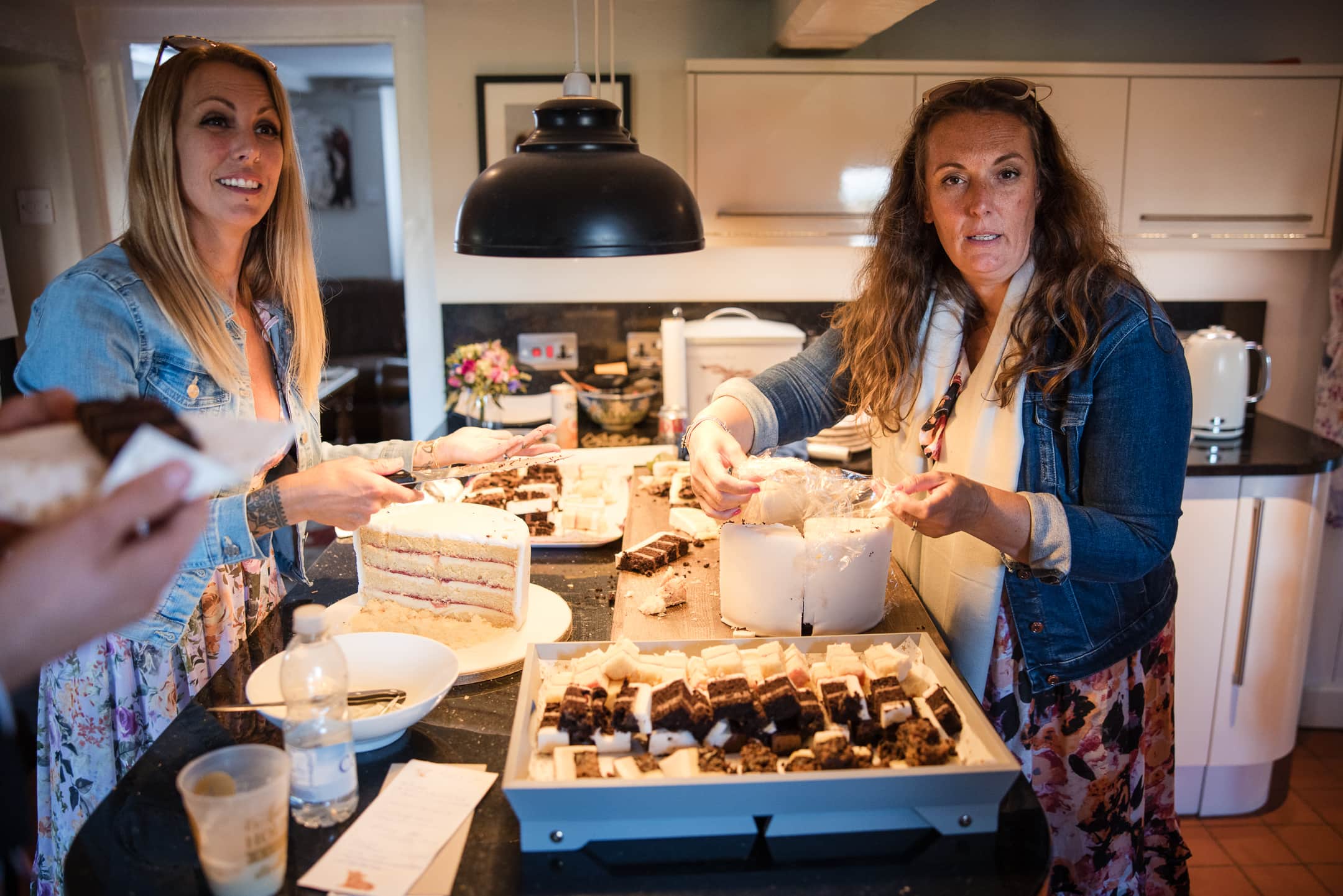 Two ladies preparing the wedding cake after the Dovecote Barn Wedding