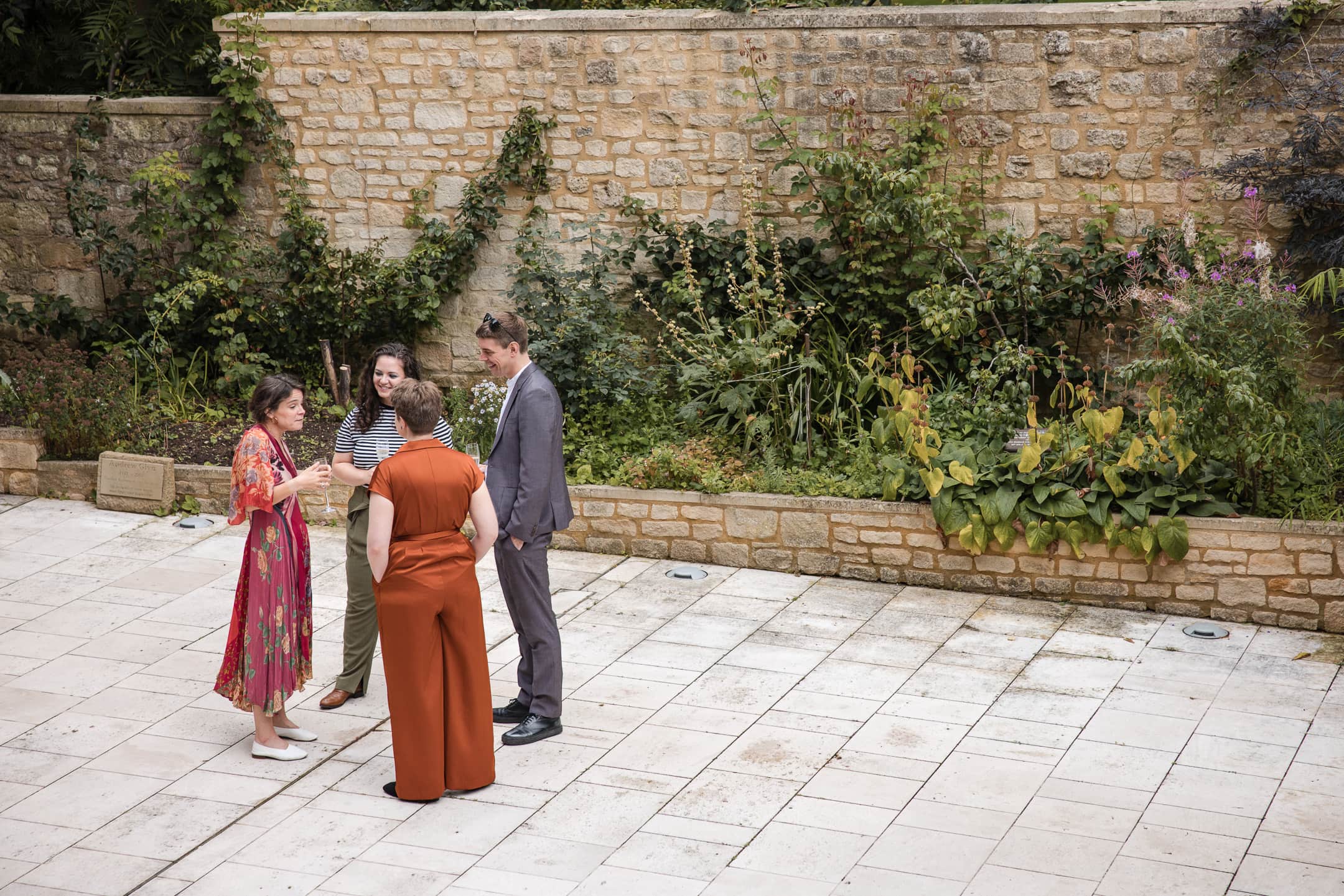 Four guests chatting in the courtyard during Corpus Christi College Oxford Wedding