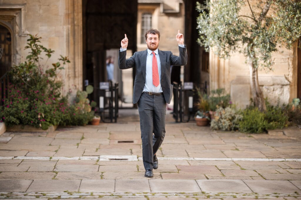 Guest gesturing in the Quad at Corpus Christi College Oxford Wedding